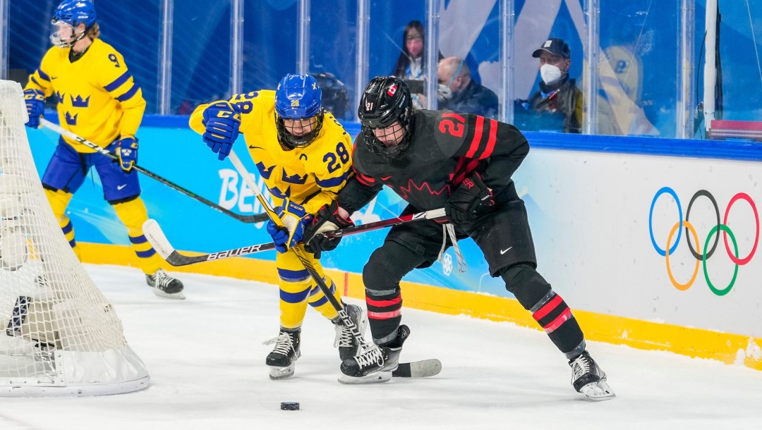 Ashton Bell fights for the puck against a Swedish player